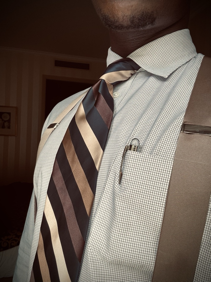 Close-up of a striped silk tie, checked shirt and pen in the pocket
